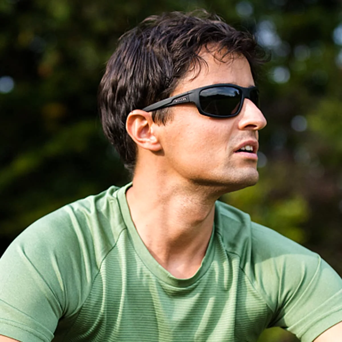 A man in a green shirt wearing the BEALER sport wrap outdoors